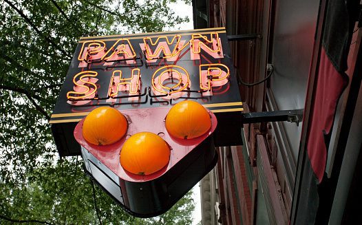 Neon pawn shop sign with three ball symbol